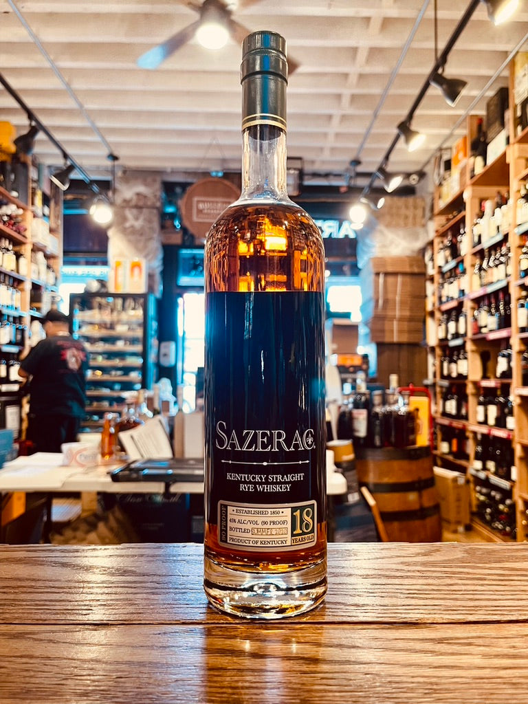 Sazerac Rye 18 Year Old 750mL a tall slender clear glass bottle with a long neck and white lettering with a dark top