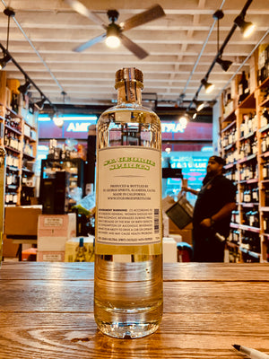 St George Green Chile Vodka 750mL the backside of a tall cylinder shaped clear glass bottle with a white label and a wooden top 