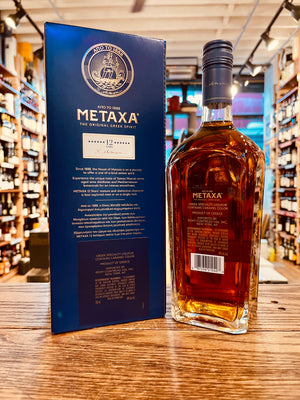 Metaxa Brandy 12 Star 750ml the backside of a tall blue box next to a clear squared bottle with a blue top
