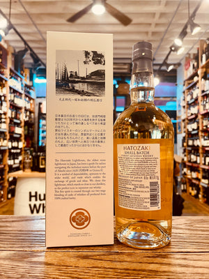 Hatozaki Small Batch Japanese Whisky 750mL the backside of a tall white box next to a clear high rounded shouldered bottle with a white label