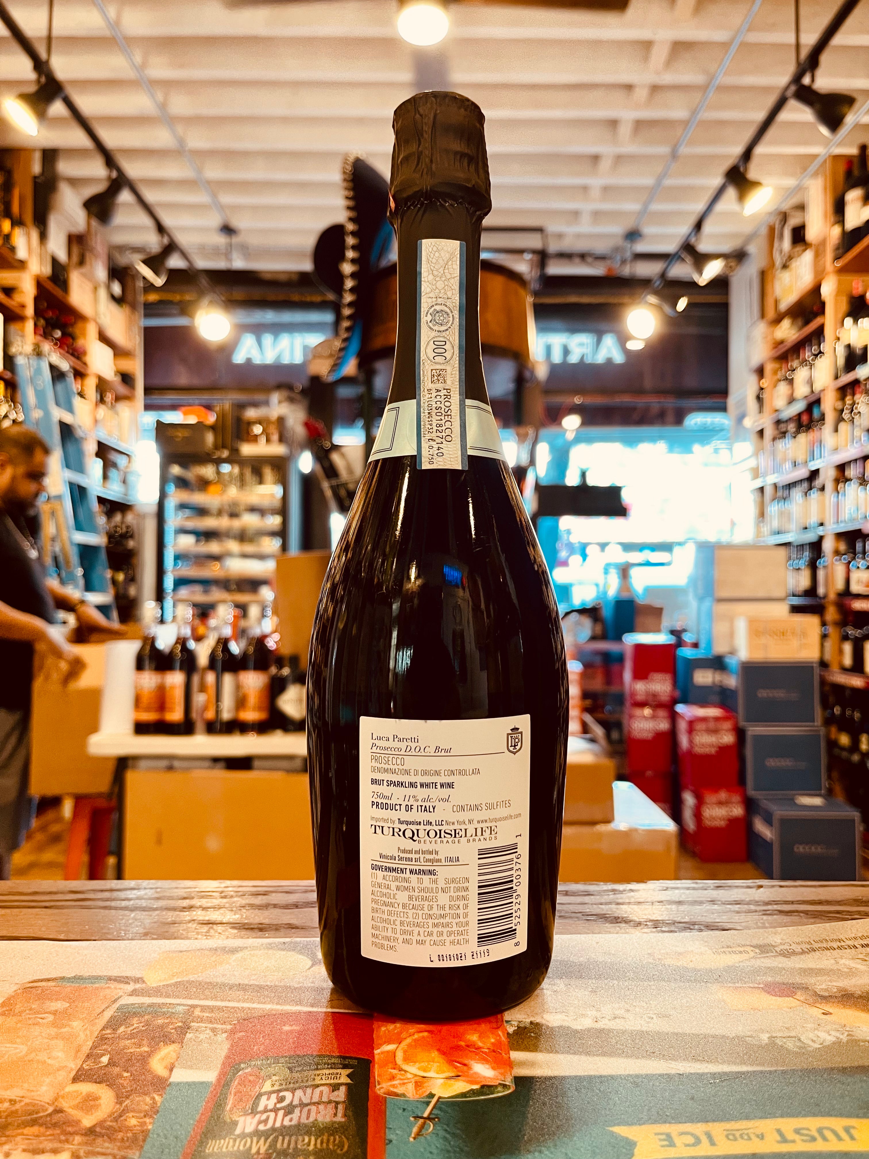 Luca Paretti Prosecco Brut 750mL the backside of a dark champagne shaped glass bottle with a white label and black top