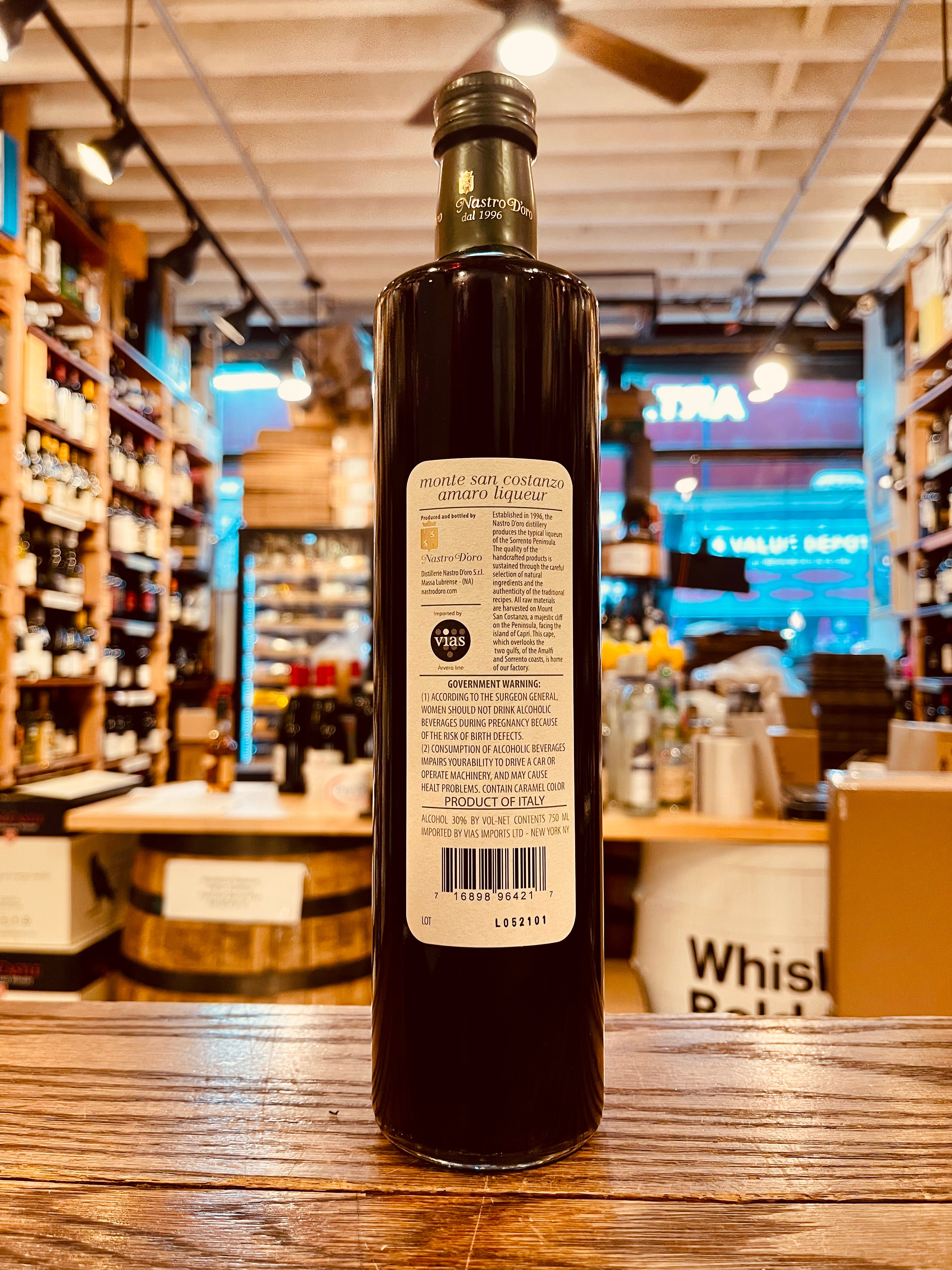 Amaro Monte San Costanzo Liqueuer 750mL tall elongated bottle with dark liquid and a white label 