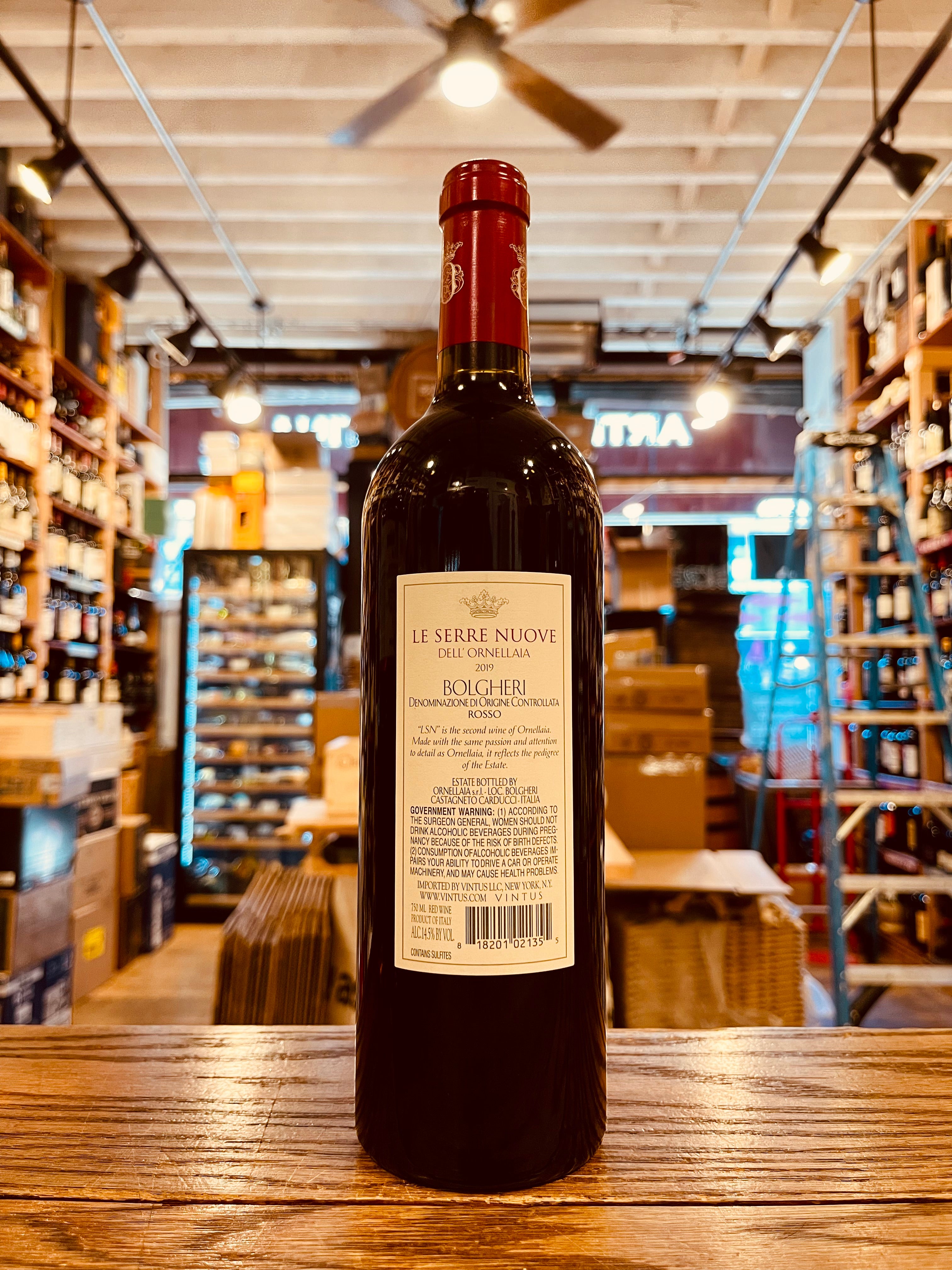 Le Serre Nuove 750mL Ornellaia 2019 the backside of a tall dark wine bottle with a white label and red top