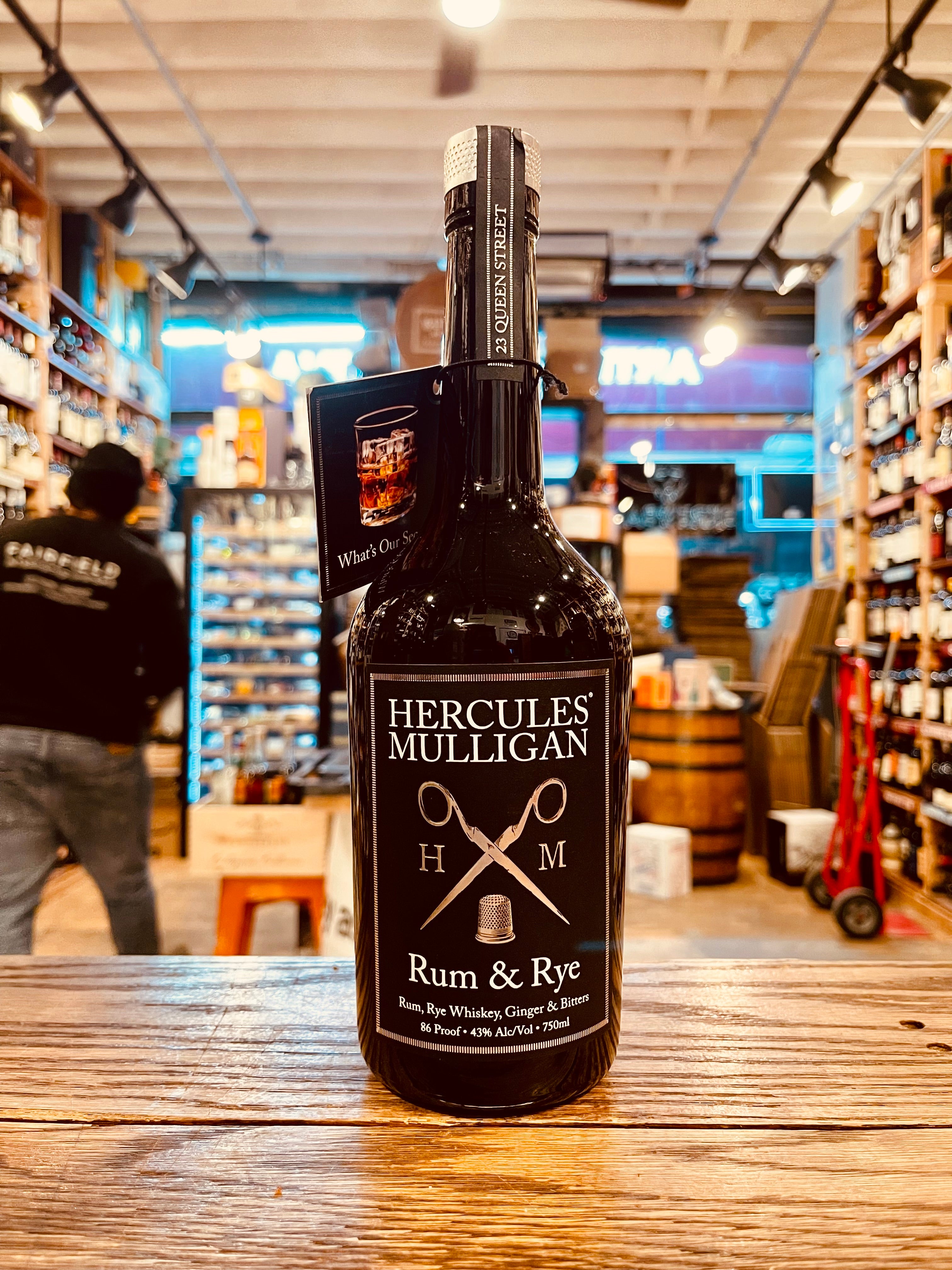 Hercules Mulligan Rum & Rye 750mL a black glass bottle with a black and silver label with the image of scissors  
