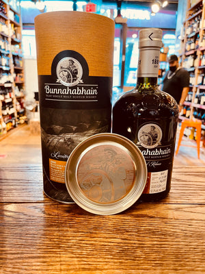 Bunnahabhain 2008 Manzanilla Islay Single Malt 750mL a yellow and dark canister next to a round shouldered dark bottle with a silver top