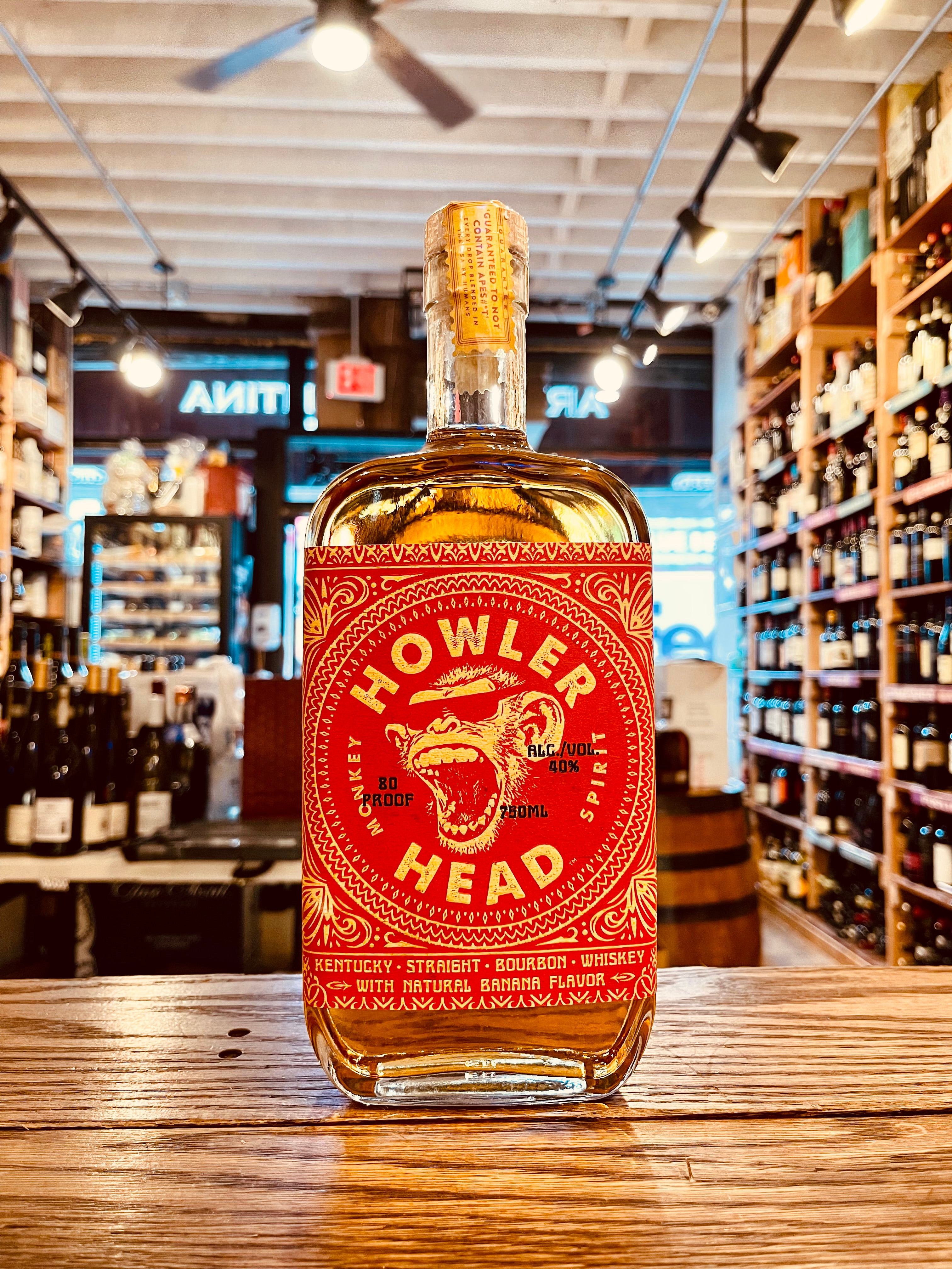 Howler Head 750mL a flat surfaced squared clear glass bottle with a red label and the image of a monkey wearing sunglasses 