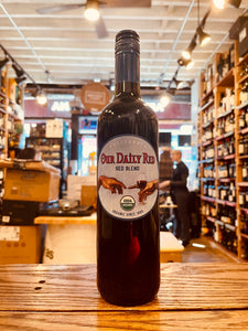 Our Daily Red 750mL Vegan a dark glass wine bottle with a blue label the image of two hands on it
