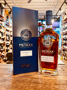 Metaxa Brandy 12 Star 750ml a tall blue and golden box next to a tall squared clear bottle with a blue top