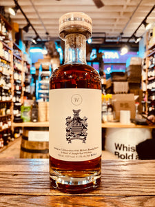 Wolves Rye Project #1 750mL a short rounded shouldered clear glass bottle with a large white label with a code of arms on the front and a wooden top