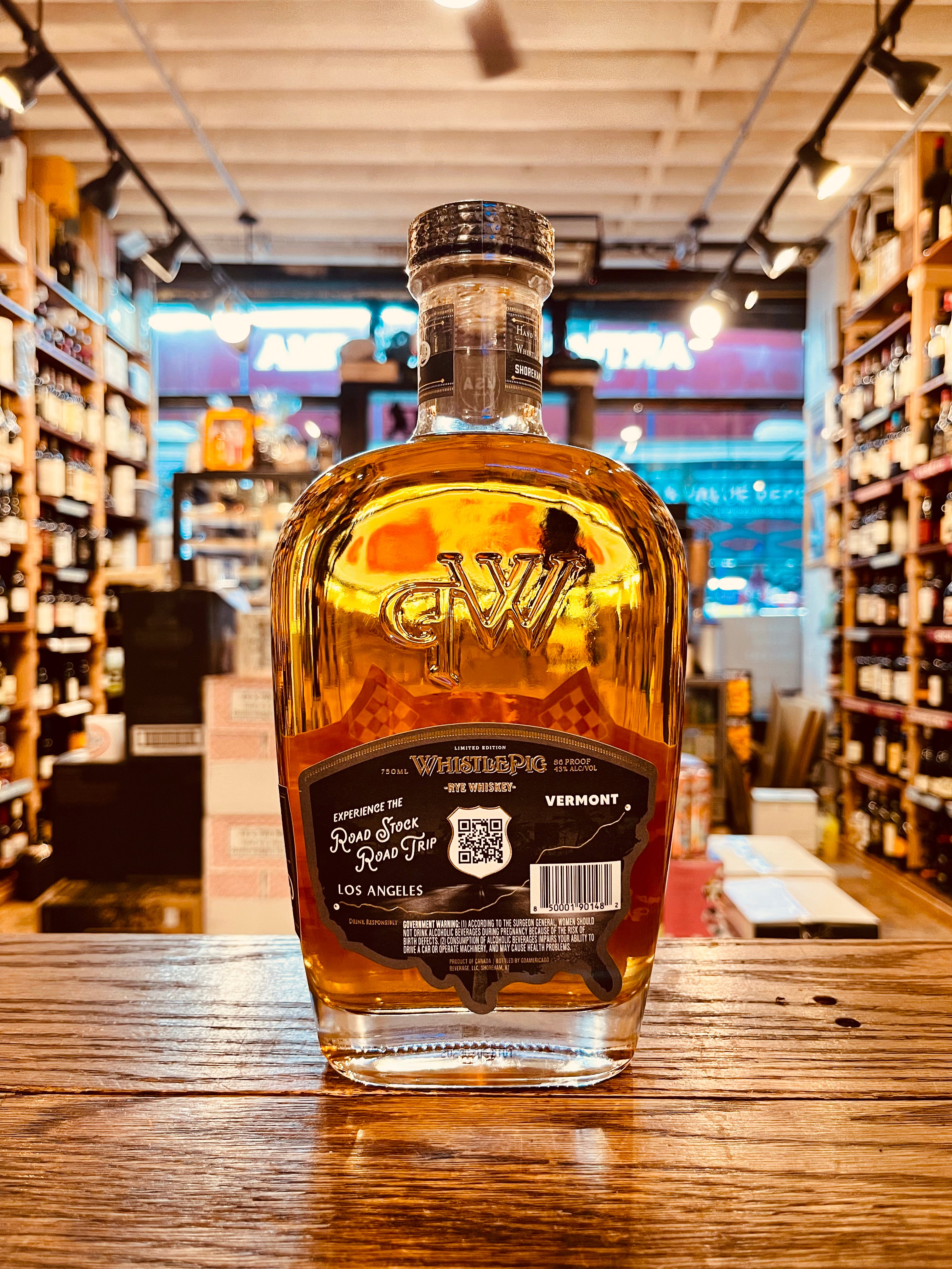 Whistle Pig Roadstock Rye Whiskey 750mL the backside of a clear glass bottle thats robust in shape with rounded shoulders and a black label and wooden top