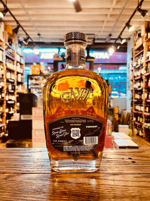 Whistle Pig Roadstock Rye Whiskey 750mL the backside of a clear glass bottle thats robust in shape with rounded shoulders and a black label and wooden top
