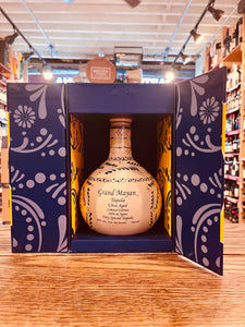 Grand Mayan Ultra Tequila Limited Edition 750mL an open blue box with a short rounded handmade ceramic bottle inside that has blue and red design painted on it.