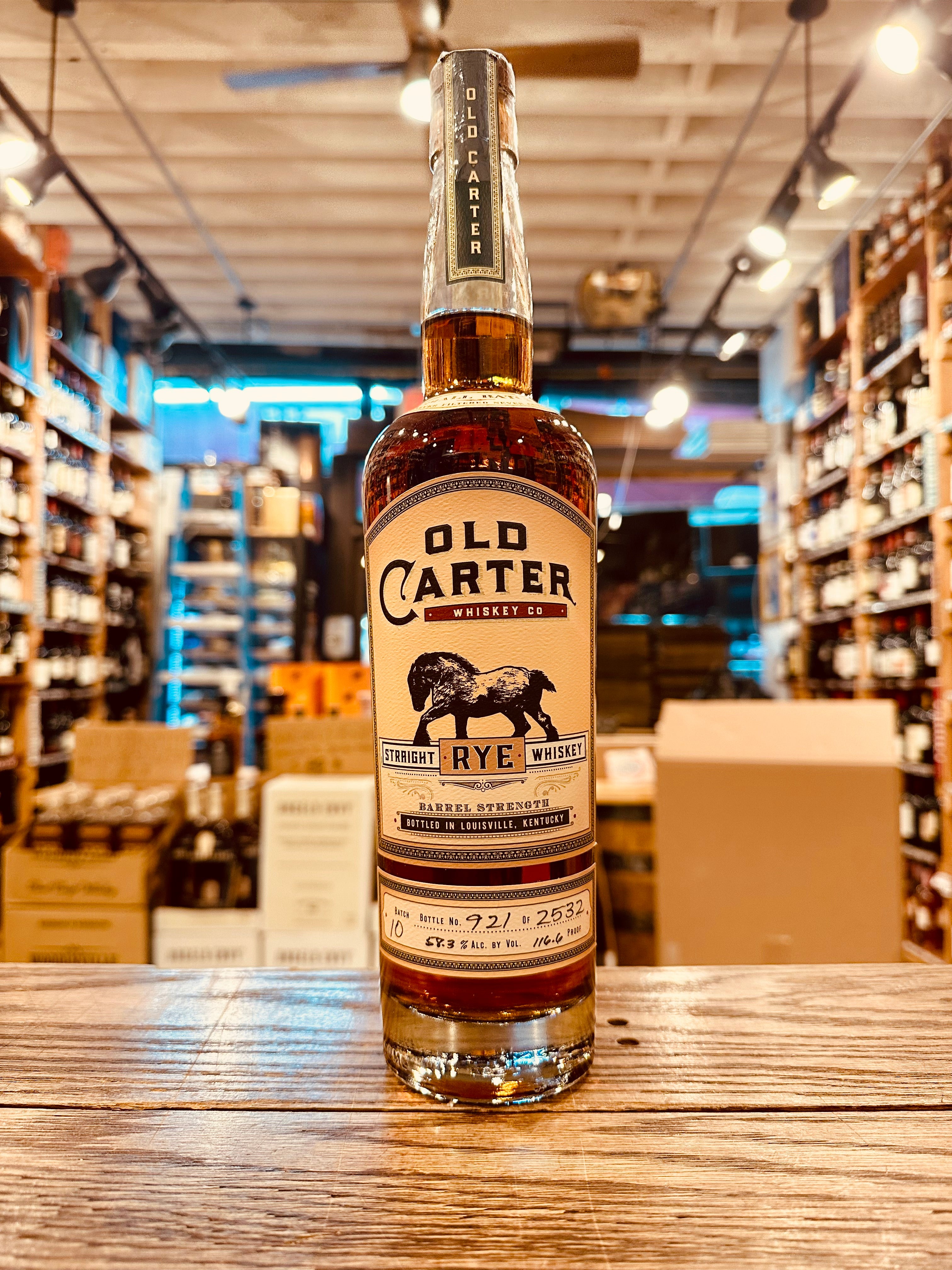 Old Carter Straight Rye Whiskey Batch #10 750mL a tall high shouldered clear glass bottle with a beige label with the image of a horse and wooden top