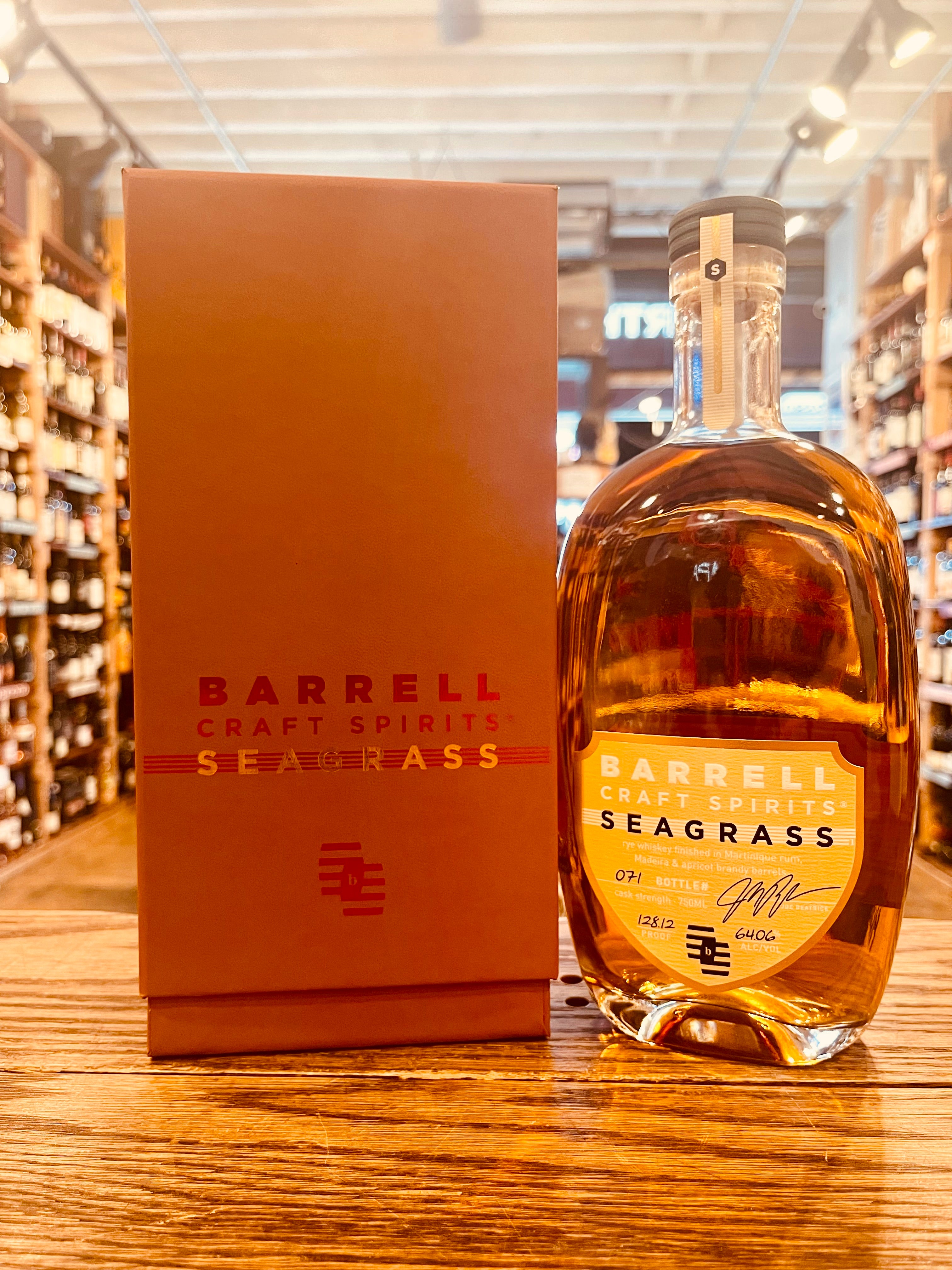 Barrell Craft Spirits Seagrass (Gold Label) 750mL a rustic colored box next to a oval shaped clear bottle with yellow labeling