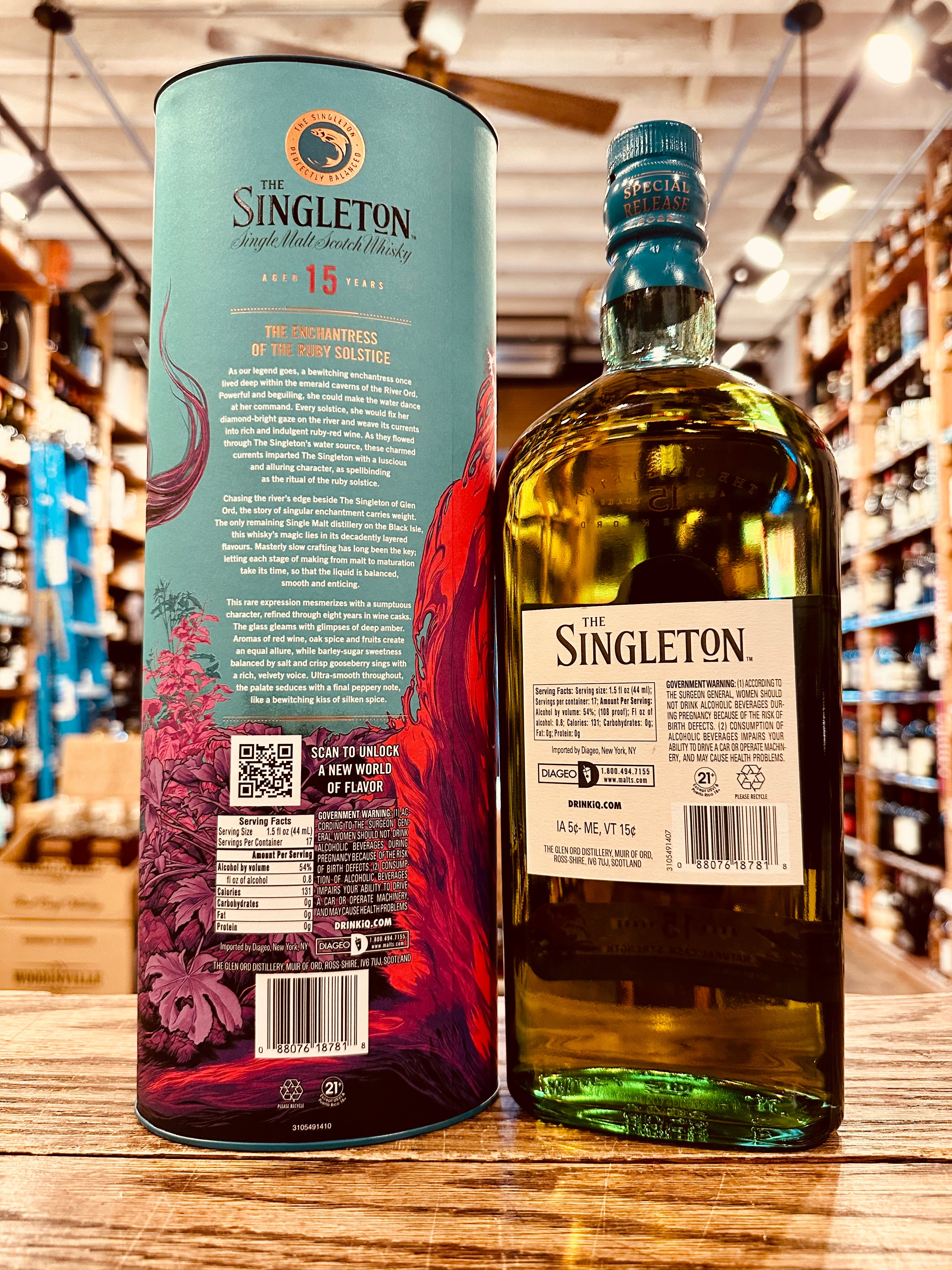 Singleton Glen Ord 15Yr Scotch Whisky 750mL the backside of a tall aqua colored tin cylinder next to a flat surfaced rounded shouldered clear glass bottle with a white label and with an  aqua green top