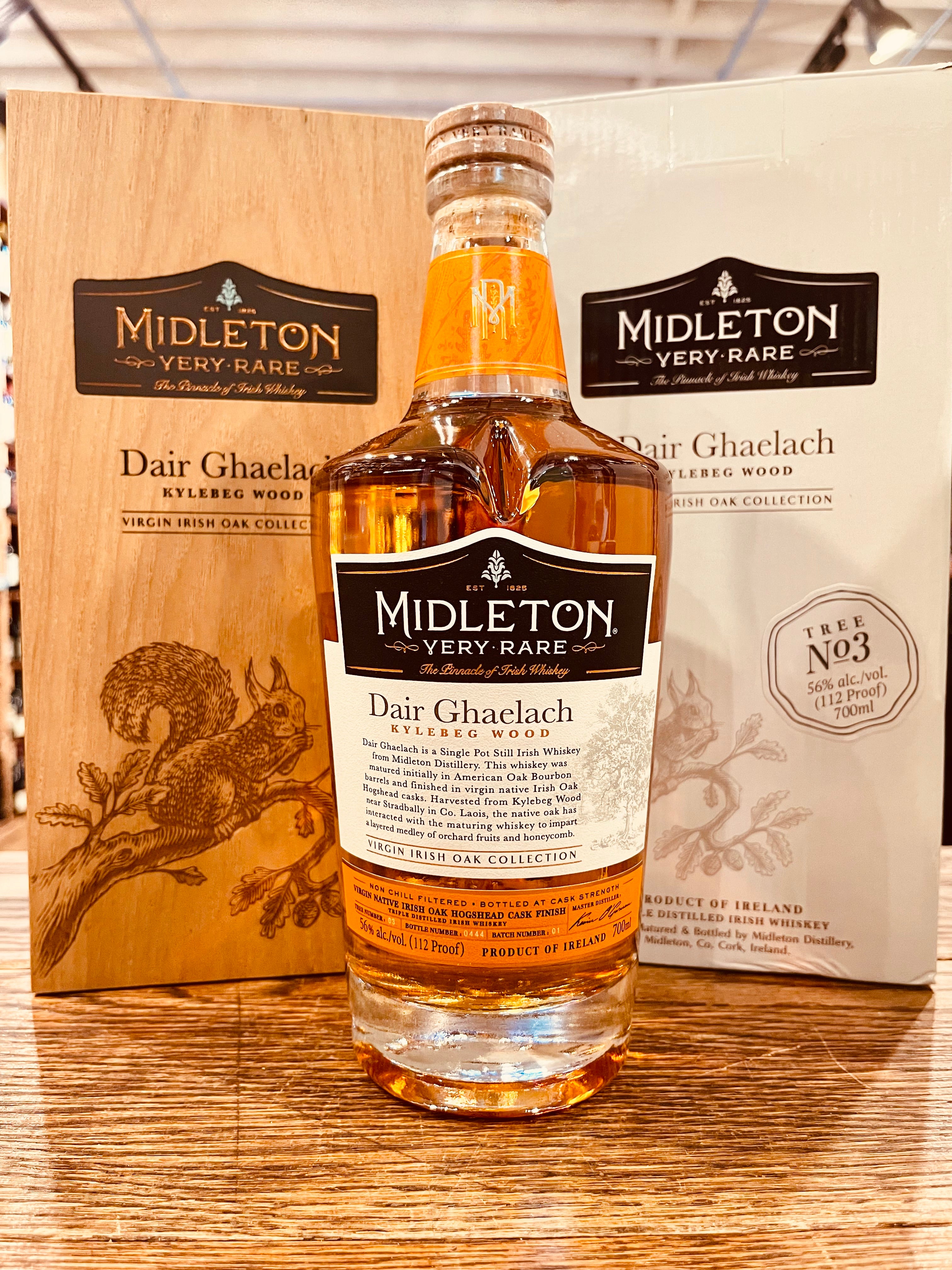 Midleton Very Rare Whiskey Dair Ghaelach Kylebeg Wood Tree No3 700mL a clear high shouldered rounded glass bottle with a white label and wooden top in front a of wooden box with an image of a squirrel next to a white cardboard box with the same image  