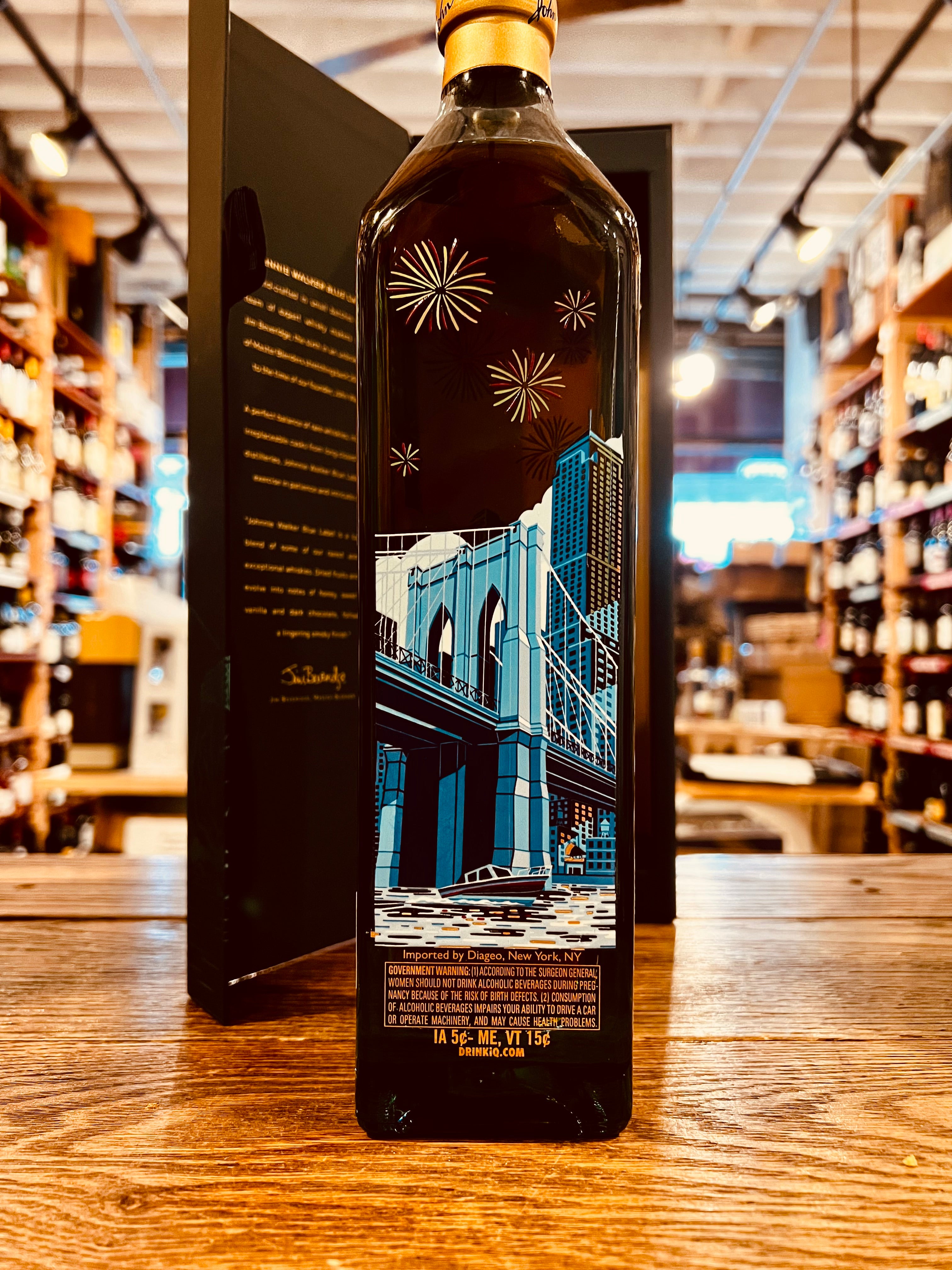 Johnnie Walker Blue Label New York Edition Scotch Whisky 750mL an open blue box with a tall squared bottle in front of it that has an image of the Brooklyn Bridge on it with a golden top