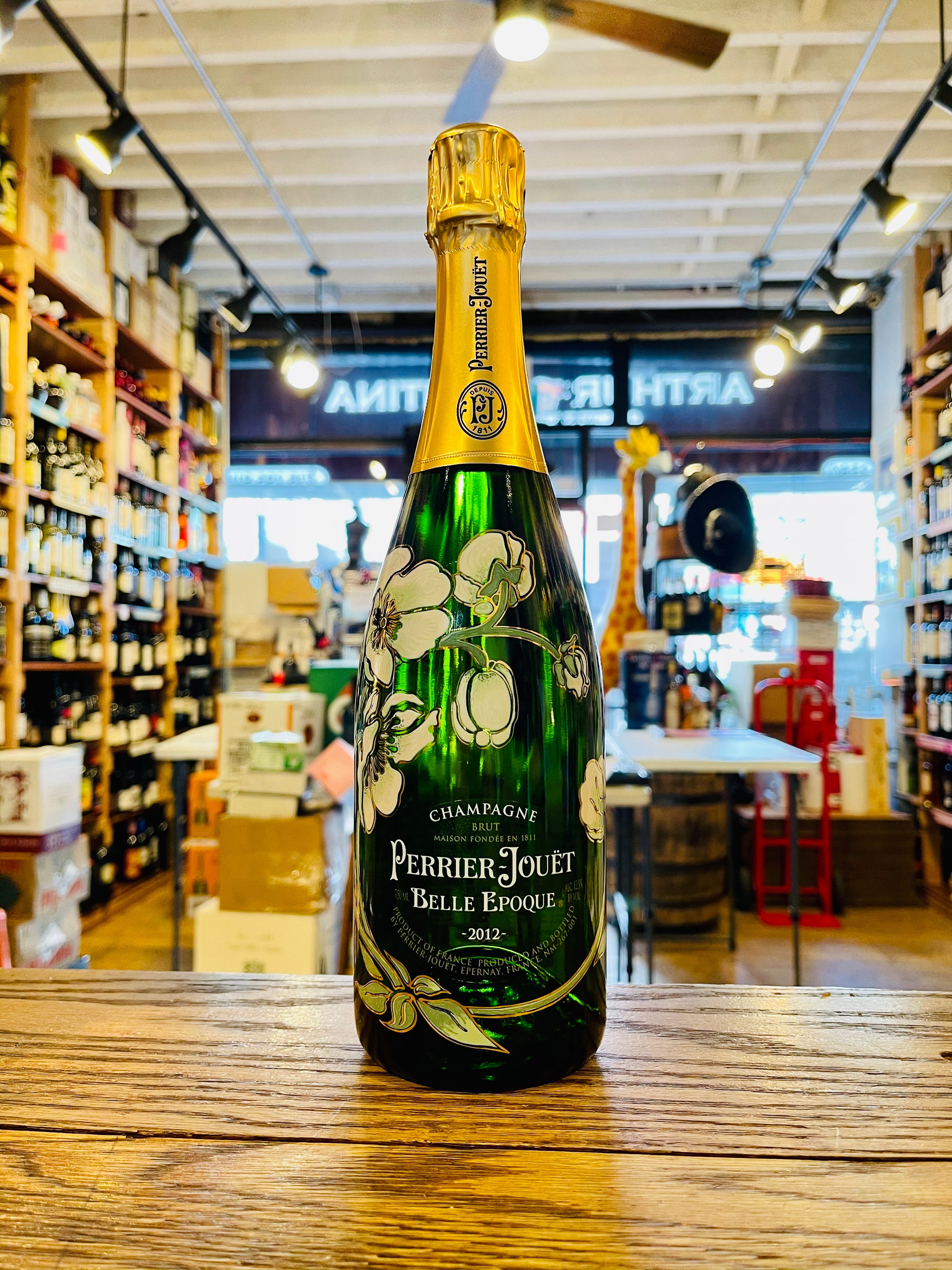 Perrier Jouet Belle Epoque 750mL a green clear glass champagne bottle with designs of flowers on the bottle and a golden top