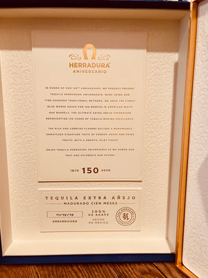 Herradura Aniversario 750mL inside of a box that is lined with white presenting a letter