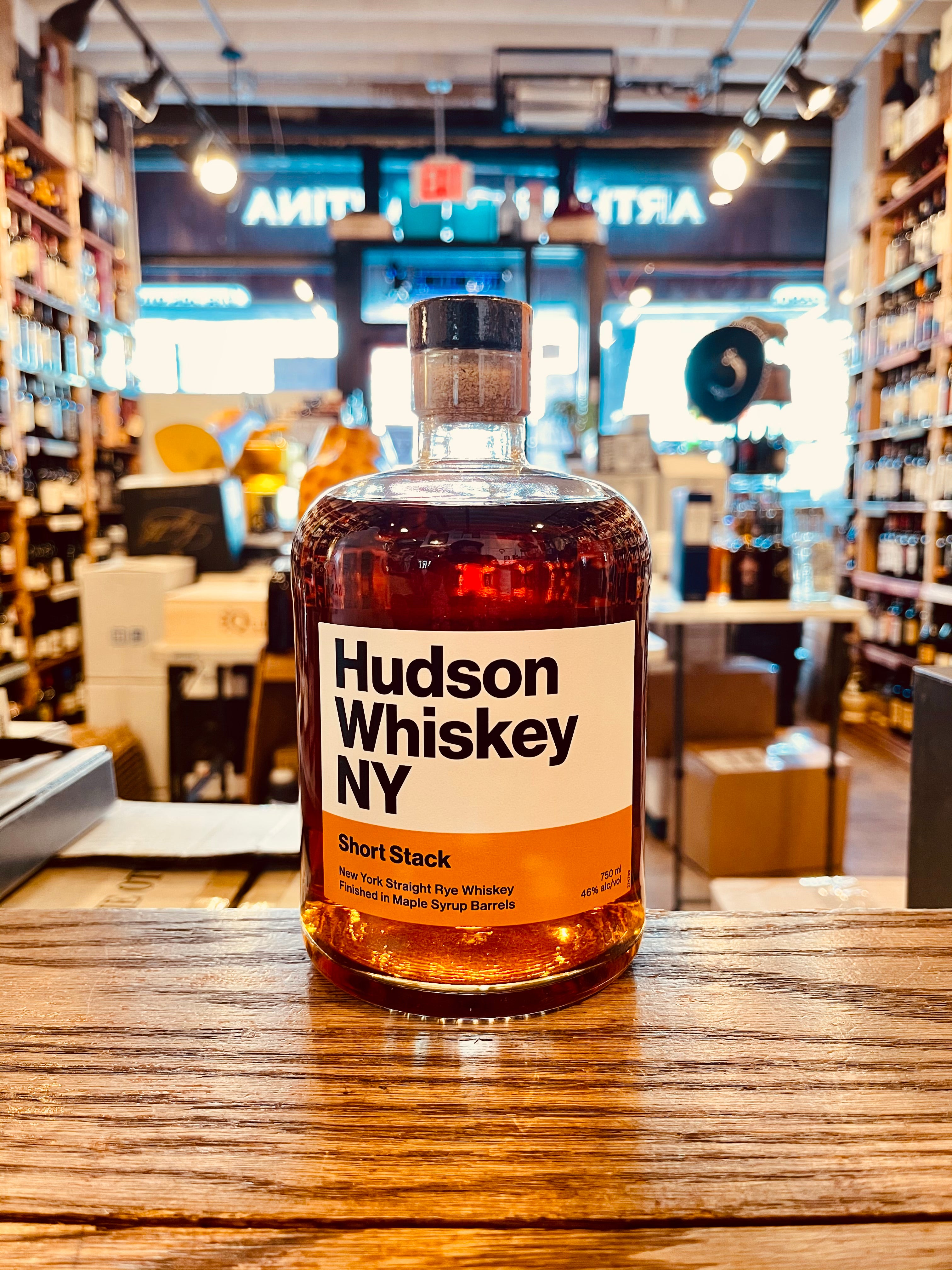 Hudson Whiskey NY Short Stack Rye 750mL a short squat rounded clear glass bottle with a short neck and white and orange label 