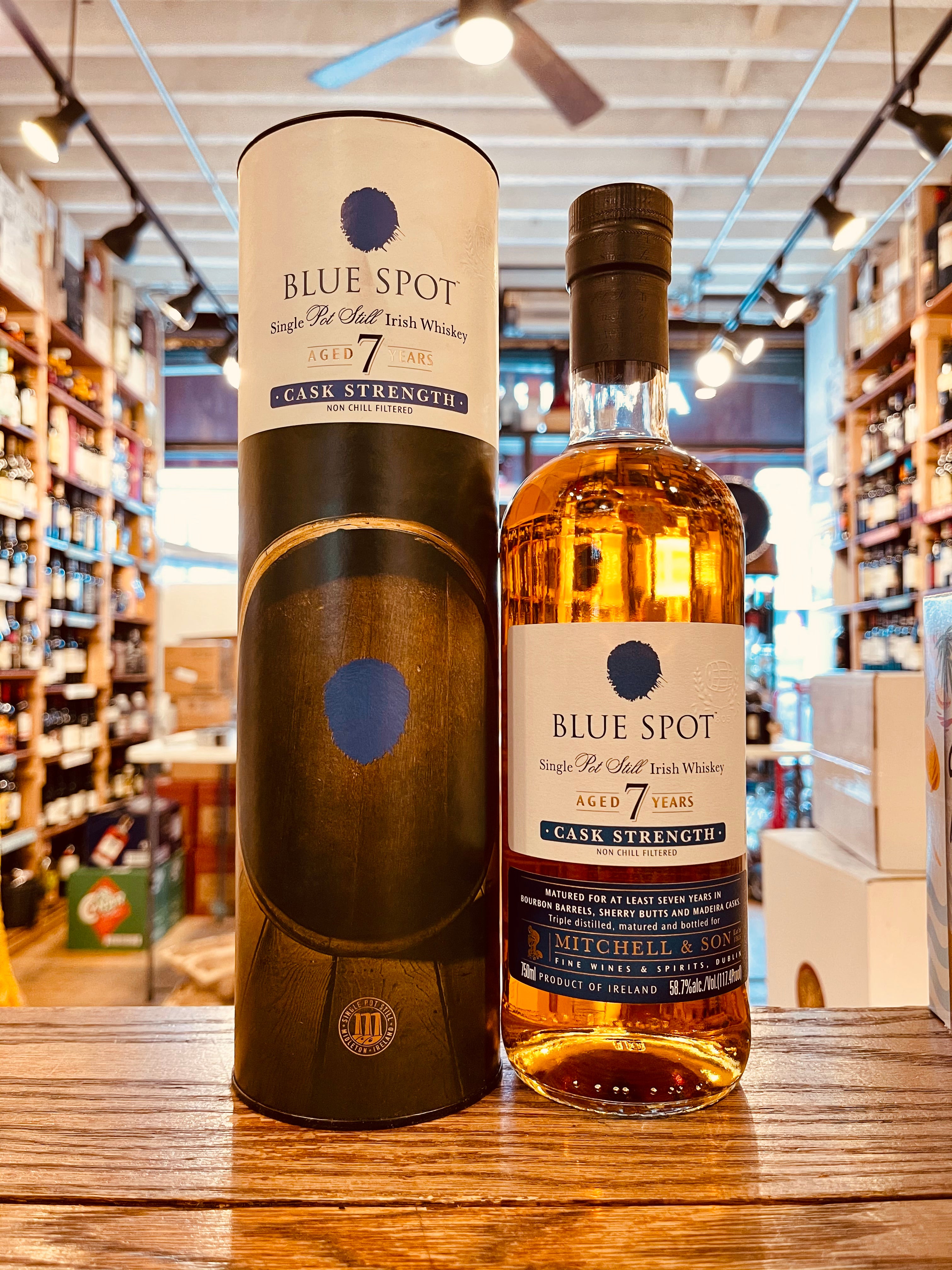 Blue Spot 7 Year Old Cask Strength 750mL a white and dark colored cylinder next to a clear bottle with a white label and blue spot