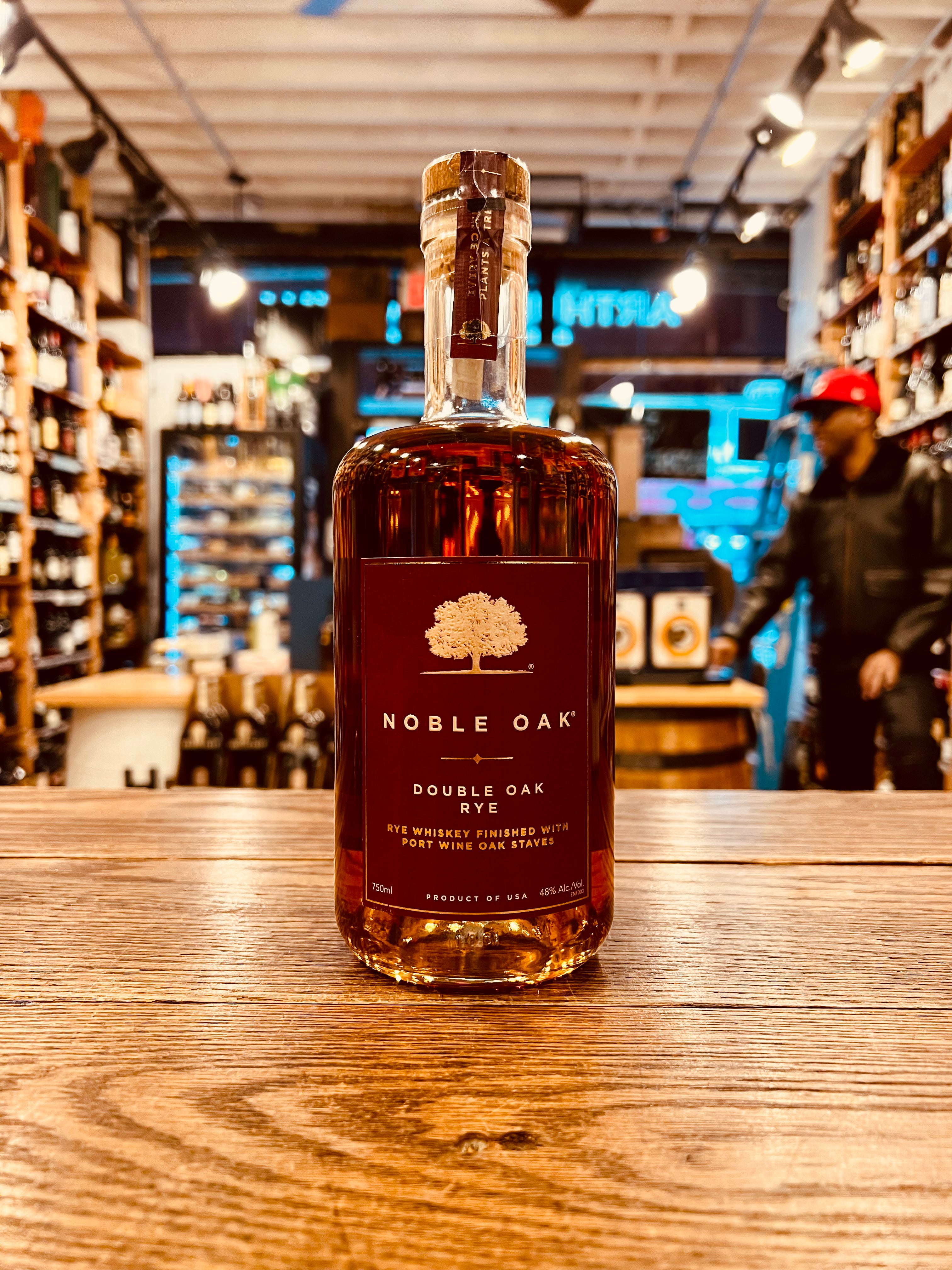 Noble Oak Double Oak Rye 750mL short round shouldered clear glass bottle with a red label and a wooden top