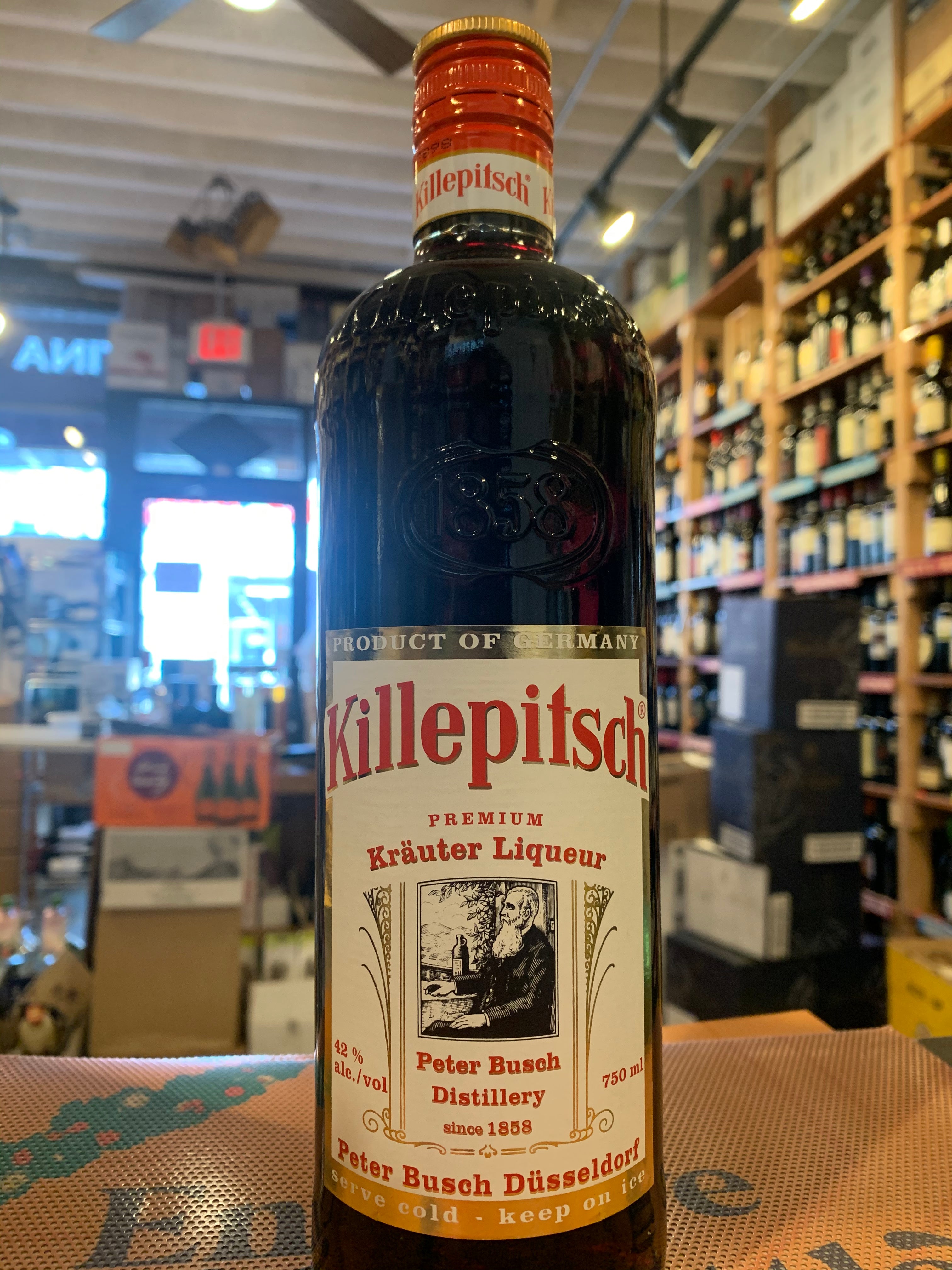 Killepitsch Herbal 750mL a tall rounded shouldered bottle with a small neck and white label and red top