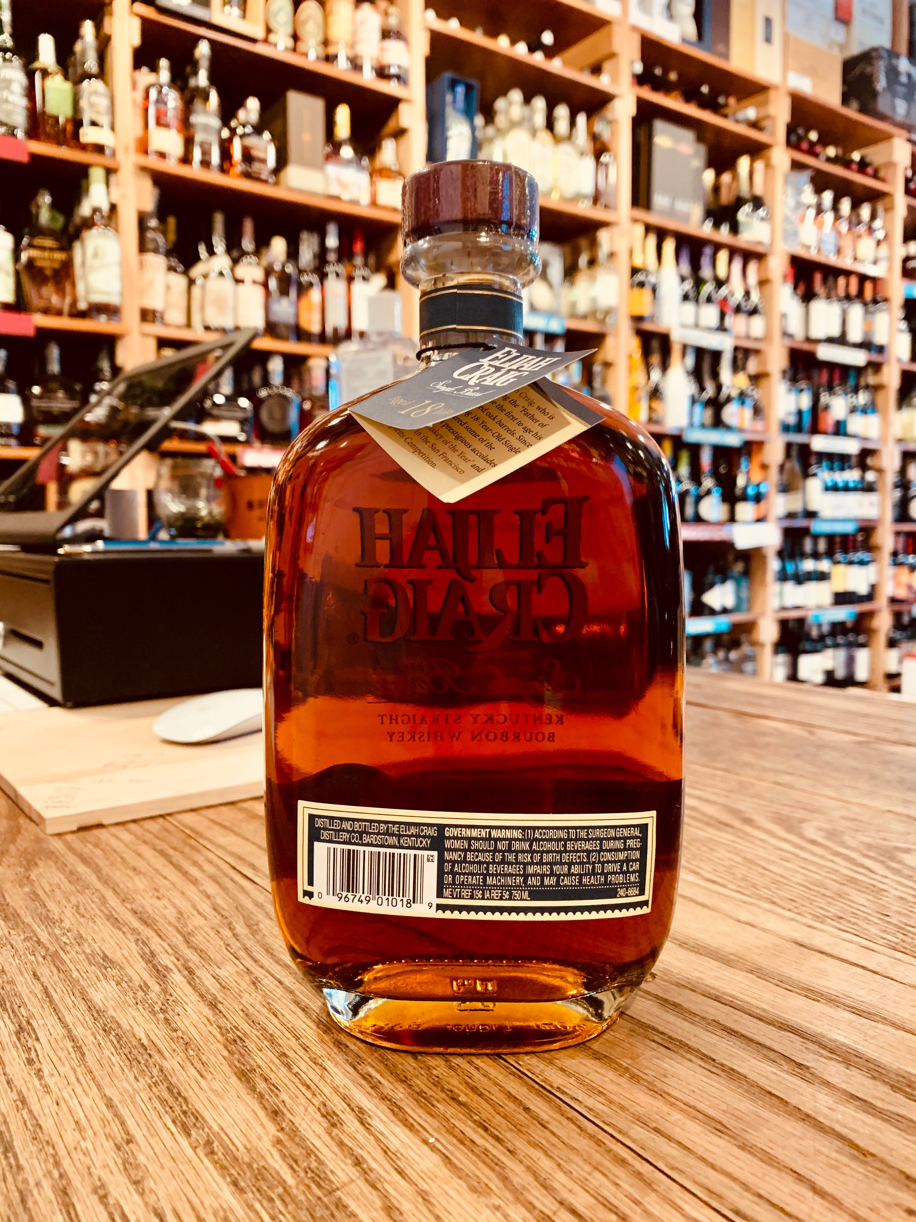 Elijah Craig Single Barrel 18yr old 750mL the backside of a flat rounded bottle with a wooden top 