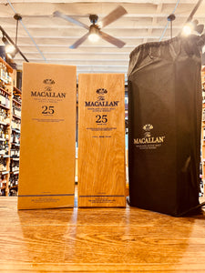 Macallan 25Yr Sherry Oak 750mL a cardboard box with black lettering, next to a smaller wooden box with black lettering, next to a tall black bag with silver lettering.